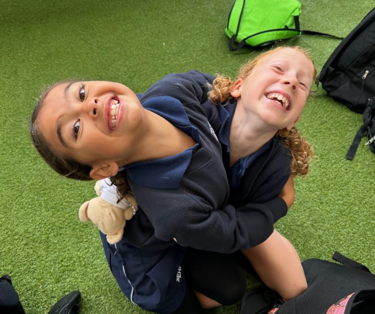 Two girls, hugging and laughing