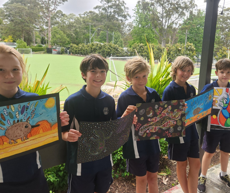 Five smiling students hold the colourful artworks they have created