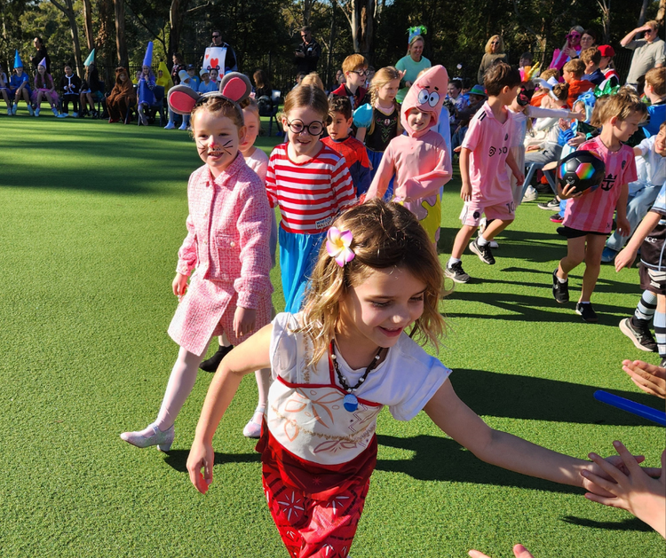 Young children walk in a line showcasing their varied Book Week costumes